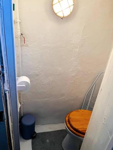 a small bathroom with a toilet with a wooden seat at Cute Marais Private Studio for 2 in Paris