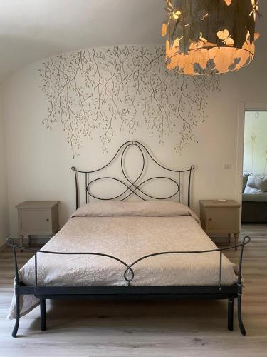 a bedroom with a bed and a chandelier at Novecento Charming Room in Avigliana