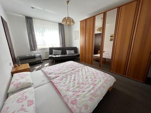 een slaapkamer met een groot bed en een bank bij Lichtdurchflutete große Wohnung in Schwelm