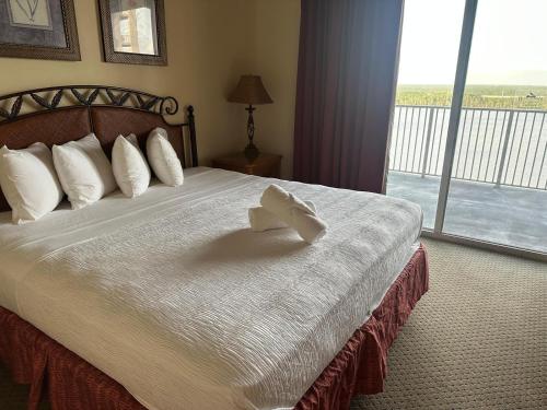 a hotel room with a bed with a bow on it at Penthouse Close to Disney area and Malls water view in Orlando