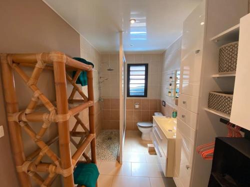 baño con escalera de madera y aseo en Cocooning Tropic Studio avec Jacuzzi privatif, en Saint-Louis