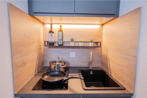 eine Küche mit einer Spüle und einem Topf auf einem Herd in der Unterkunft Apartments an der Universität in Wuppertal