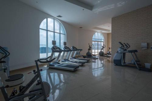 a gym with a row of tread machines in a room at 08B Luxury Oceanfront Resort Lifestyle Panama in ArraijÃ¡n