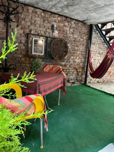 patio con mesa, sillas y pared de ladrillo en Hostel Nomad en Tiflis