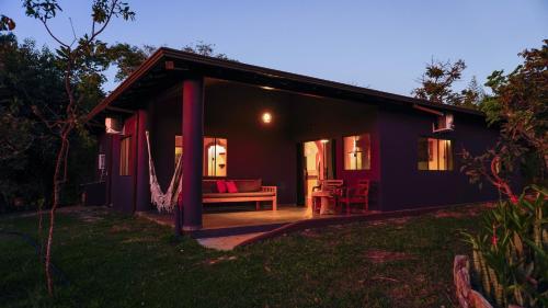 a black house with a porch and a couch at Terra Coral - Chapada dos Veadeiros in Alto Paraíso de Goiás