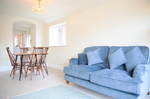 ein blaues Sofa im Wohnzimmer mit einem Tisch in der Unterkunft Bridgnorth Town House in Bridgnorth