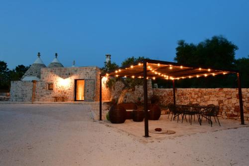 a table and chairs under a tent with lights at Trulli di Titti - Luxury Country House in Castellana Grotte