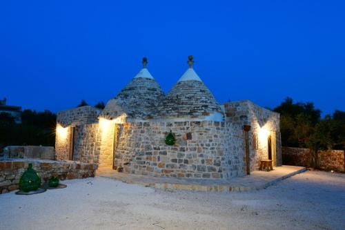 a stone building with lights on it at night at Trulli di Titti - Luxury Country House in Castellana Grotte