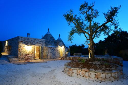a building with a tree in front of it at Trulli di Titti - Luxury Country House in Castellana Grotte