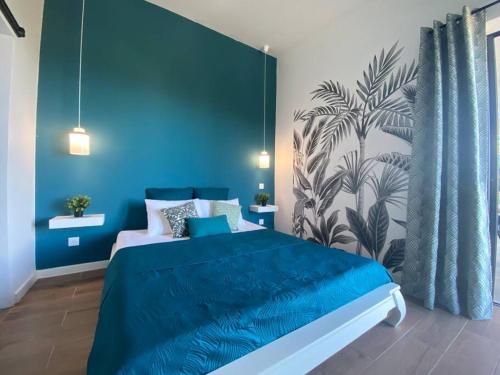 um quarto azul com uma cama grande e lençóis azuis em Cocoon Love avec piscine privative em Saint-Louis