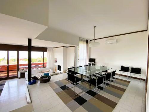 a dining room with a glass table and black chairs at VILLA SETTANTA Lago di Garda - Heated Pool on request in Bardolino