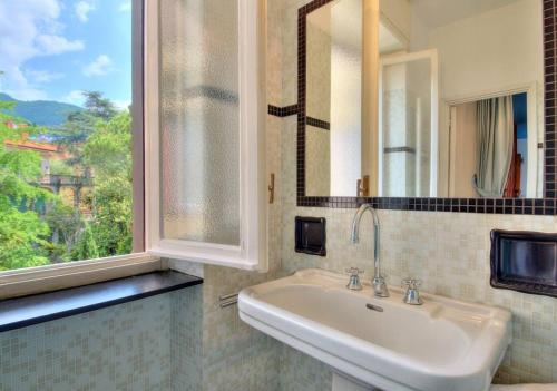 une salle de bain avec un lavabo et une fenêtre dans l'établissement Dolce Acqua Flexyrent apartment Terrace & Parking - NO AC, à Rapallo