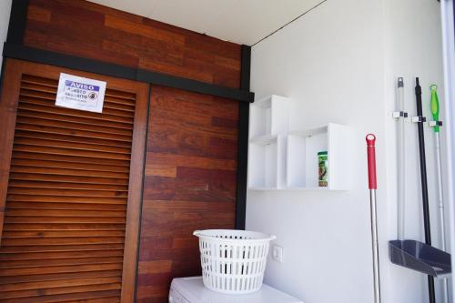 a bathroom with a wooden door and a refrigerator at Casa Amélia in Feteira Grande