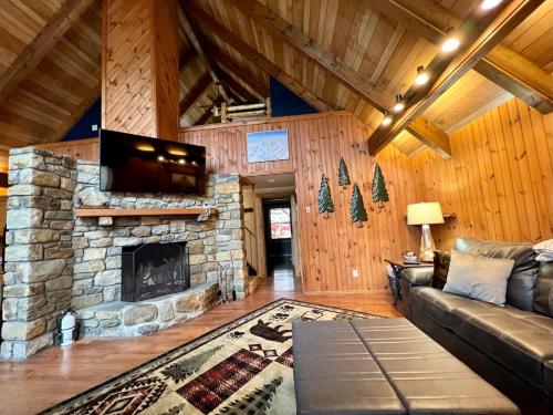 a living room with a couch and a stone fireplace at Abundant Acres Retreat in Beech Mountain