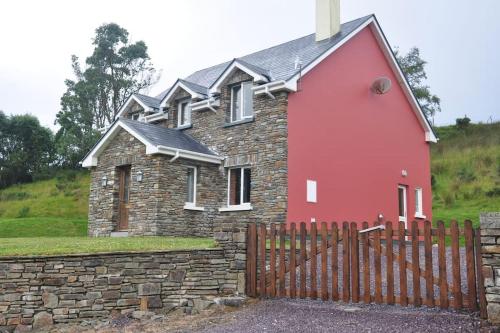 a red church with a brick fence and a fence at Grace's Landing in Sneem