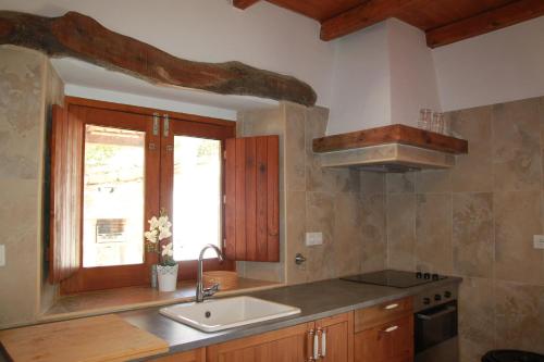een keuken met een wastafel en een raam bij Corvatos Casas do Monte in Almodôvar
