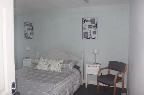 a bedroom with a bed and a chair and pictures on the wall at Tansterne Grange in Aldbrough