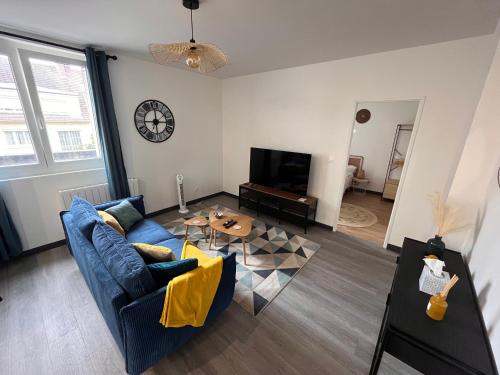 uma sala de estar com um sofá azul e uma mesa em Appartement f2 Résidence Nassau em Beauvais