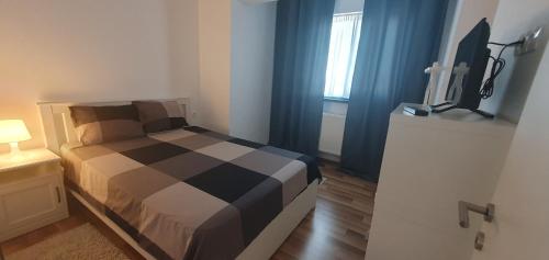 een slaapkamer met een bed en een televisie. bij Welcome In(n) Central Pitești in Piteşti