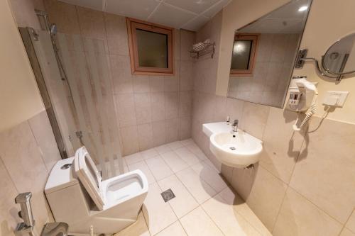 a bathroom with a toilet and a sink at Burj Al Hayat Hotel Suites - Al Olaya in Riyadh