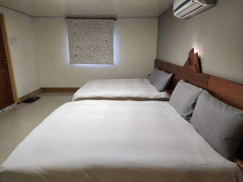 2 camas individuais num quarto com uma janela em Lilyfarm B&B em Yuli