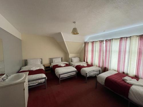 a hotel room with three beds and a sink at ST NICHOLAS HOTEL in Kenton