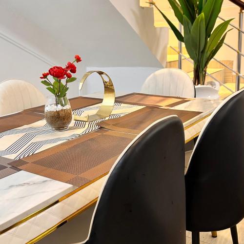 a dining room table with chairs and a vase of flowers at Luxury Shortlet Apartment Ajah, Lekki Lagos in Lagos