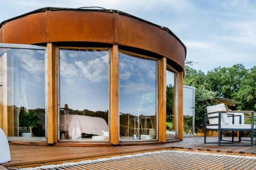une maison ronde avec une grande fenêtre sur une terrasse dans l'établissement La Belle Ronde, à Sénac