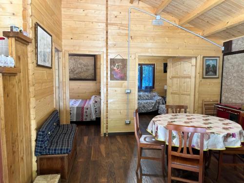 ein Esszimmer mit einem Tisch und ein Schlafzimmer in der Unterkunft CARPE DIEM RETAFANI Roger's house in Altipiani di Arcinazzo