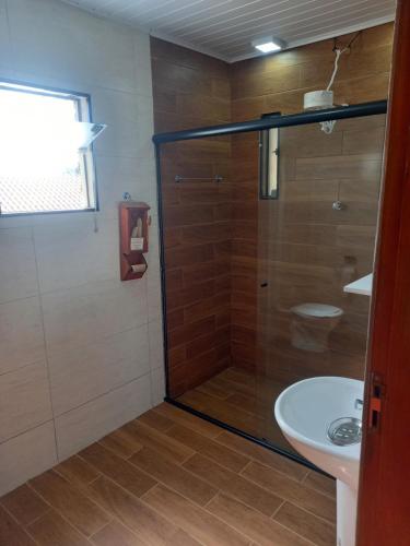 a bathroom with a shower and a sink at Chácara dos Ypes in Bueno Brandão