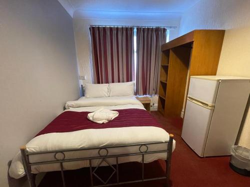 a small bedroom with two beds and a refrigerator at ST NICHOLAS HOTEL in Kenton