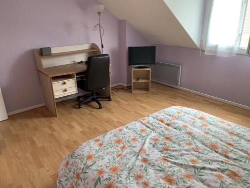 een slaapkamer met een bed, een bureau en een computer bij Chambres d'hôtes dans le Val d'Oise in Le Plessis-Bouchard
