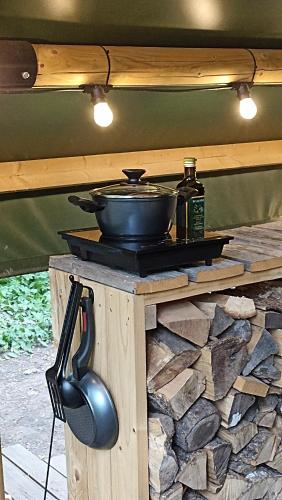 a frying pan and a pot on a stone table at Mežurgu teltis in Dikļi