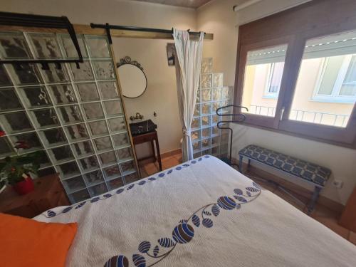 1 dormitorio con cama, ventana y espejo en DUNA Y DANA en Palamós