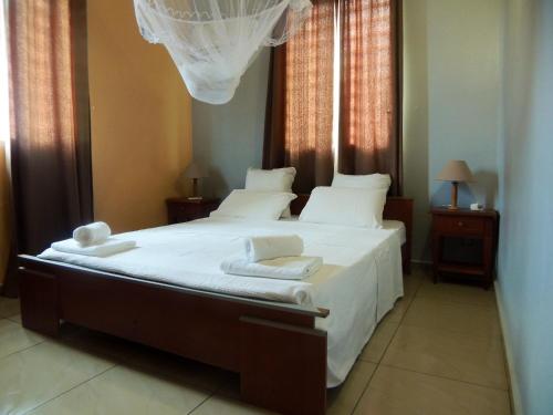 a bedroom with a large bed with white sheets and pillows at Maison lumineuse à Bouillante avec vue sur la mer in Bouillante