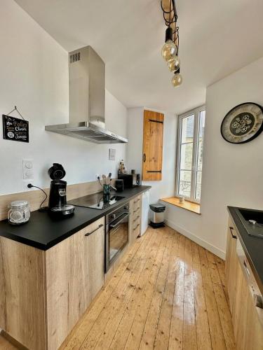 uma cozinha com bancada e piso em madeira em LE POLE CHERBOURGEOIS em Cherbourg en Cotentin