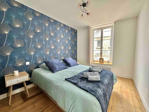 um quarto com uma cama com uma parede azul em LE POLE CHERBOURGEOIS em Cherbourg en Cotentin