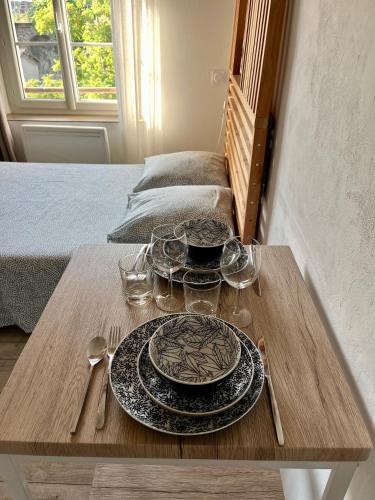 une table avec des assiettes et des verres au-dessus dans l'établissement Les Glycines, charmant studio au calme dans bâtisse de Maître proche du centre ville parking gratuit, à Digne-Les-Bains