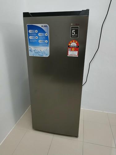 a gray refrigerator with stickers on the side of it at Adempuri Homestay 3 in Jitra