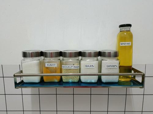 a shelf with jars of food and a bottle of oil at Adempuri Homestay 3 in Jitra