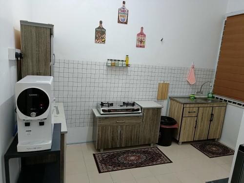 a small kitchen with a machine on a counter at Adempuri Homestay 3 in Jitra
