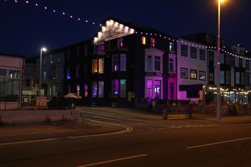 a building with purple lights on a street at night at Ferny House in Blackpool