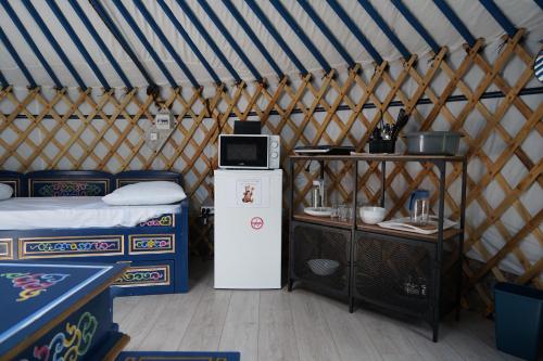 Una habitación con cama y microondas en una yurta en Les insolites de la Baie, en Longroy