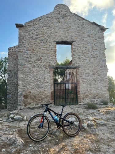 a bike parked in front of a stone building at Casa rural El encanto in Zarra