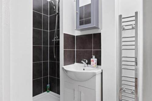 a bathroom with a sink and a shower at Fantastic 2BD Barking stay with links to the City! in London