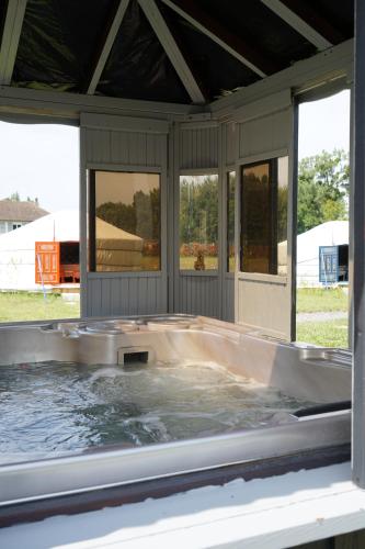 una bañera de hidromasaje en la parte trasera de una casa en Les insolites de la Baie, en Longroy