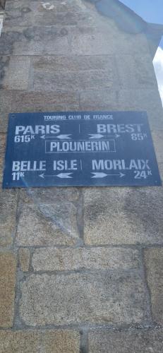 a blue sign on the side of a brick sidewalk at La petite Bretonne in Plounérin