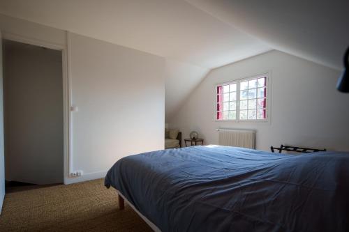 - une chambre avec un lit bleu et une fenêtre dans l'établissement Maison avec vue sur Loire proche de Chambord, à Saint-Dyé-sur-Loire