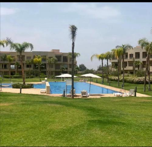 een zwembad met palmbomen en een gebouw bij appartement piscine in Marrakesh