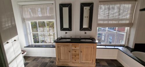 a bathroom with two sinks and two windows at Amsterdam Mansion - Twiske in Oostzaan